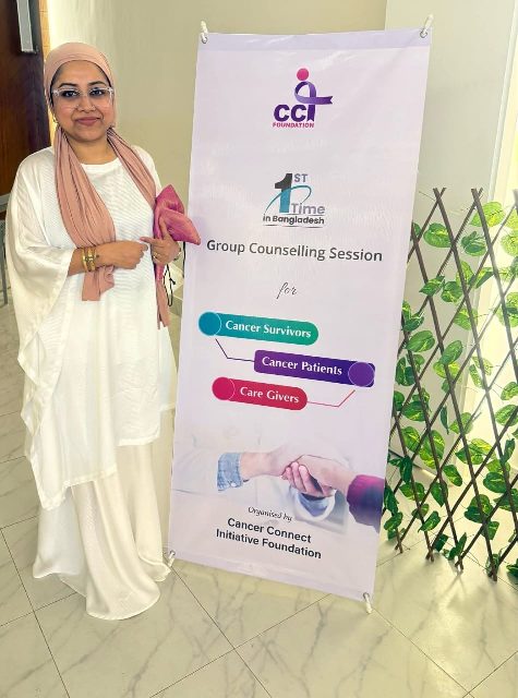 A CCI Foundation member beside the banner for the group counselling session for cancer survivors, patients and caregivers